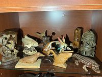 Group view of all carved wood figures on shelf