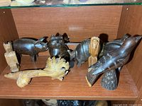 group of seven carved wood figures on shelf