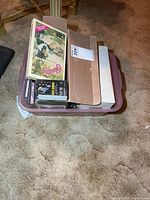 Plastic tote filled with cassette tapes and cardboard separator