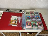 Binder exterior and first sleeve showing Pokémon action cards and sealed accessory bag