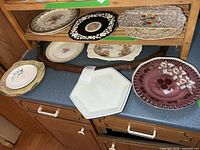 Group view of all seven collector plates on countertop and shelf