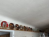 Long view of approximately twenty display plates on wall rack