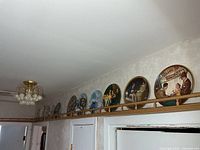 Hallway shelf with row of eleven decorative plates