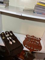 two wooden racks with collector spoons