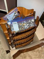 three wooden spoon racks stacked with four bags of spoons in cardboard box