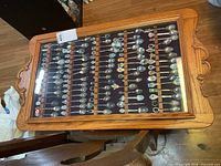 Top view of closed wooden display case filled with collector spoons