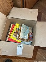 Box open showing several spiral-bound cookbooks