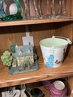Cottage and metal pail on shelf