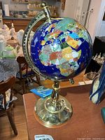 Full view of gemstone globe on brass base