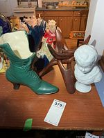 Group shot showing porcelain bust, green ceramic boot planter, carved wood rooster and wooden stand