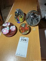 All four glass paperweights on tabletop