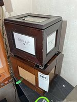 Bombay Company photo storage box stacked on top of unbranded wooden box