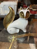 Full view of white porcelain fox with gold face and tail