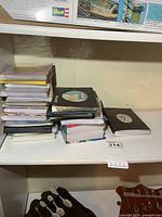 Stacked postcard albums on shelf