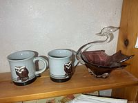 overall view of two owl mugs and art glass bird bowl