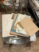 Stack of assorted loose prints on table