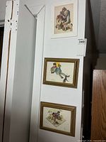 Three framed Norman Rockwell prints mounted on wall