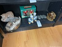 Shelf with cougar sculpture, boxed Santa shakers, sailor shakers, binocular shakers, and moose figurine