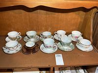 Ten assorted cup and saucer pairs on shelf