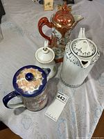 Overview of all four porcelain teapots on table