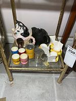 All items grouped on shelf showing teapots, egg cups, banks and timer