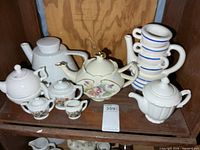 All teapots grouped on shelf showing variety and quantity