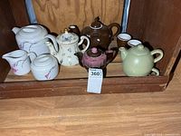 Group shot of all teapots, cups, cream and sugar