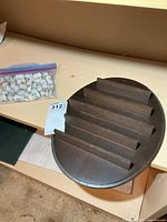 Bagged collection of porcelain thimbles and separate wooden display shelf on table