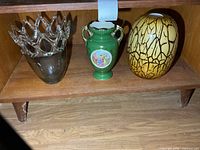 Three vases on wooden shelf