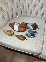 Group of six carved duck figurines on sofa