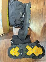 side view of overshoes showing upper material, buckle, and sole profile