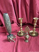 Group shot of five brass items: two candlesticks, vase, elephant figurine, eyeliner container