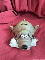 Front view of resin dog piggy bank showing eyes, nose and overall form