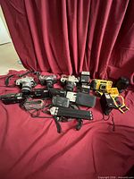 Group shot of all cameras, lenses, tripod and accessories laid out on red backdrop