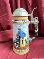 Front view showing sailor, child, dog scene and pewter lid