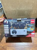 Front of box showing RCA RPJ199-COMBO projector image and bundle details