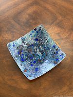 Top view showing blue speckled interior of square enamel bowl