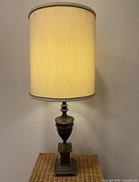 Full view of brass lamp with shade lit