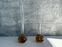 Two amber-based clear bud vases side by side