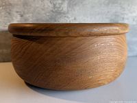 Side view of teak bowl showing exterior grain and rounded lip