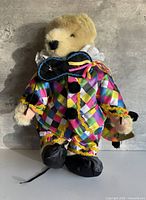 Full view of plush bear in harlequin costume