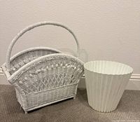 white wicker magazine holder and pleated waste basket side by side