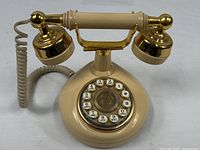 Full view of cream and gold French cradle telephone
