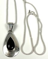 Front view of sterling silver teardrop pendant with black onyx on chain