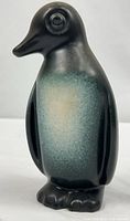 Front view of ceramic penguin showing gradient glaze and feet detail