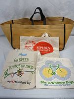 Overall group of totes including large tan tote and three printed canvas totes