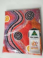 Front view of packaged tea towel showing overall Aboriginal dot art design