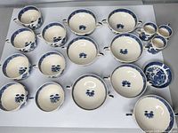 Full layout showing 14 bowls, 2 mugs and saucer with Blue Willow pattern