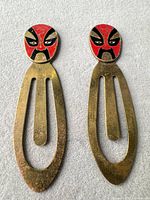 Front view of both bookmarks showing enamel mask designs and overall shape