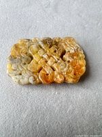 Front view of carved jade plaque showing color variation and openwork details